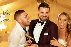 Nathan Cassar, MC with a wedding groom who is smiling towards him on the his left and a bride smiling looking forward and holding Nathan's right arm